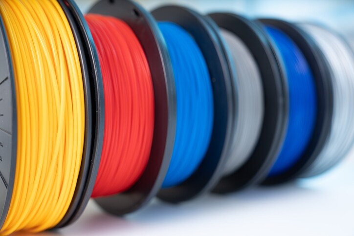 Multiple colors of 3d printing filament spools lined up in a row